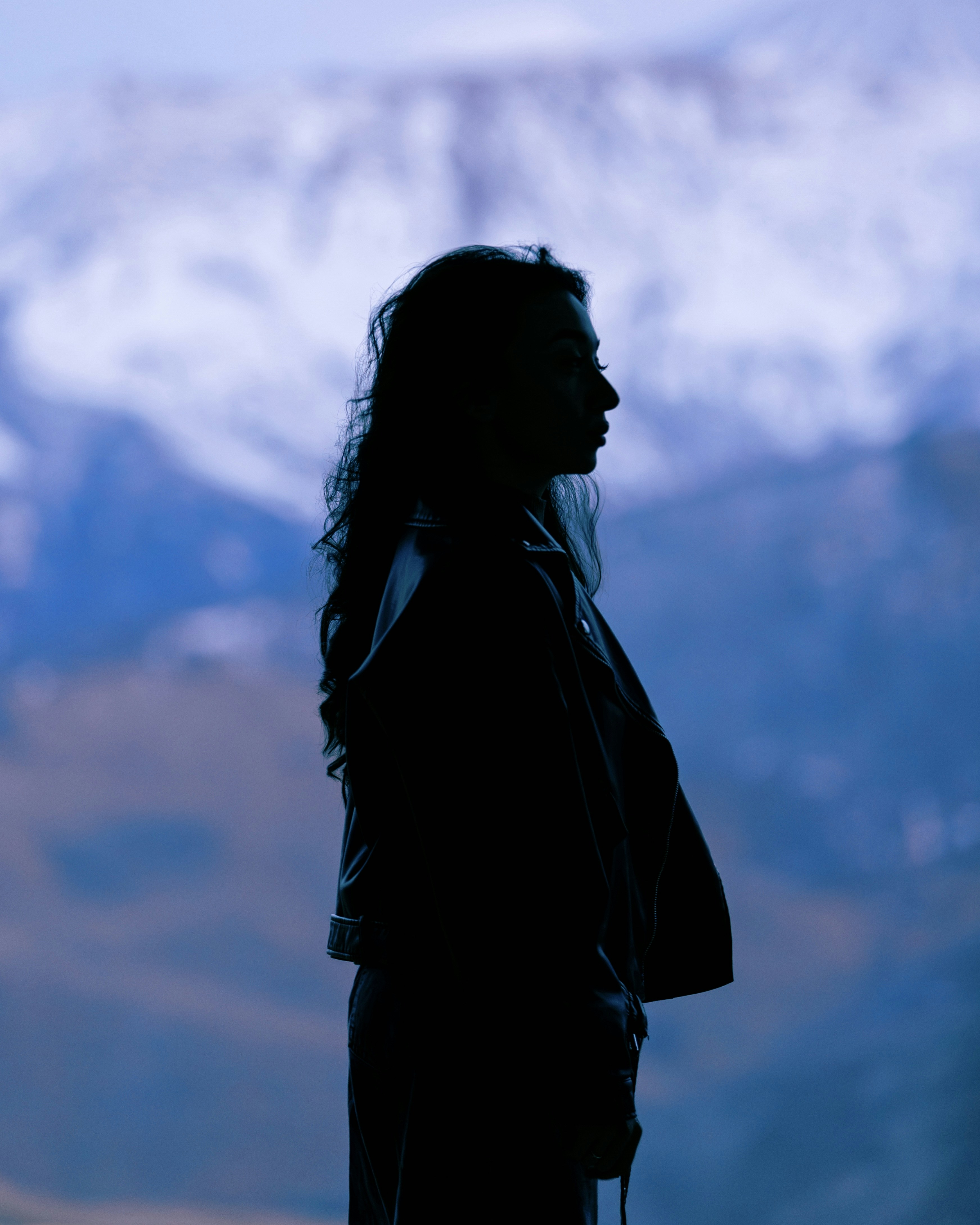 Silhouette of a woman against a mountain backdrop