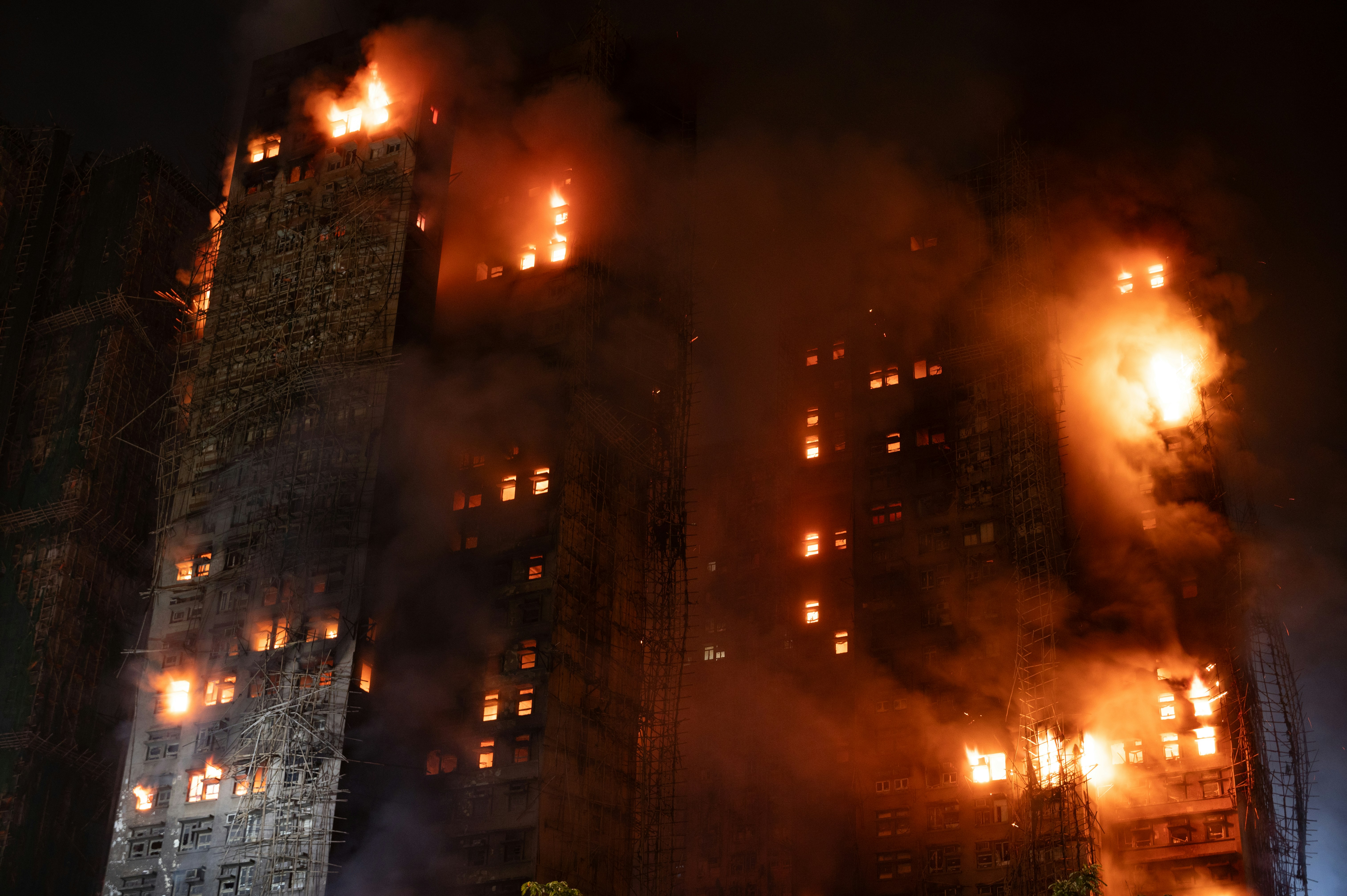 A tall building engulfed in flames at night