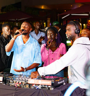Dj performing with singers at an outdoor event