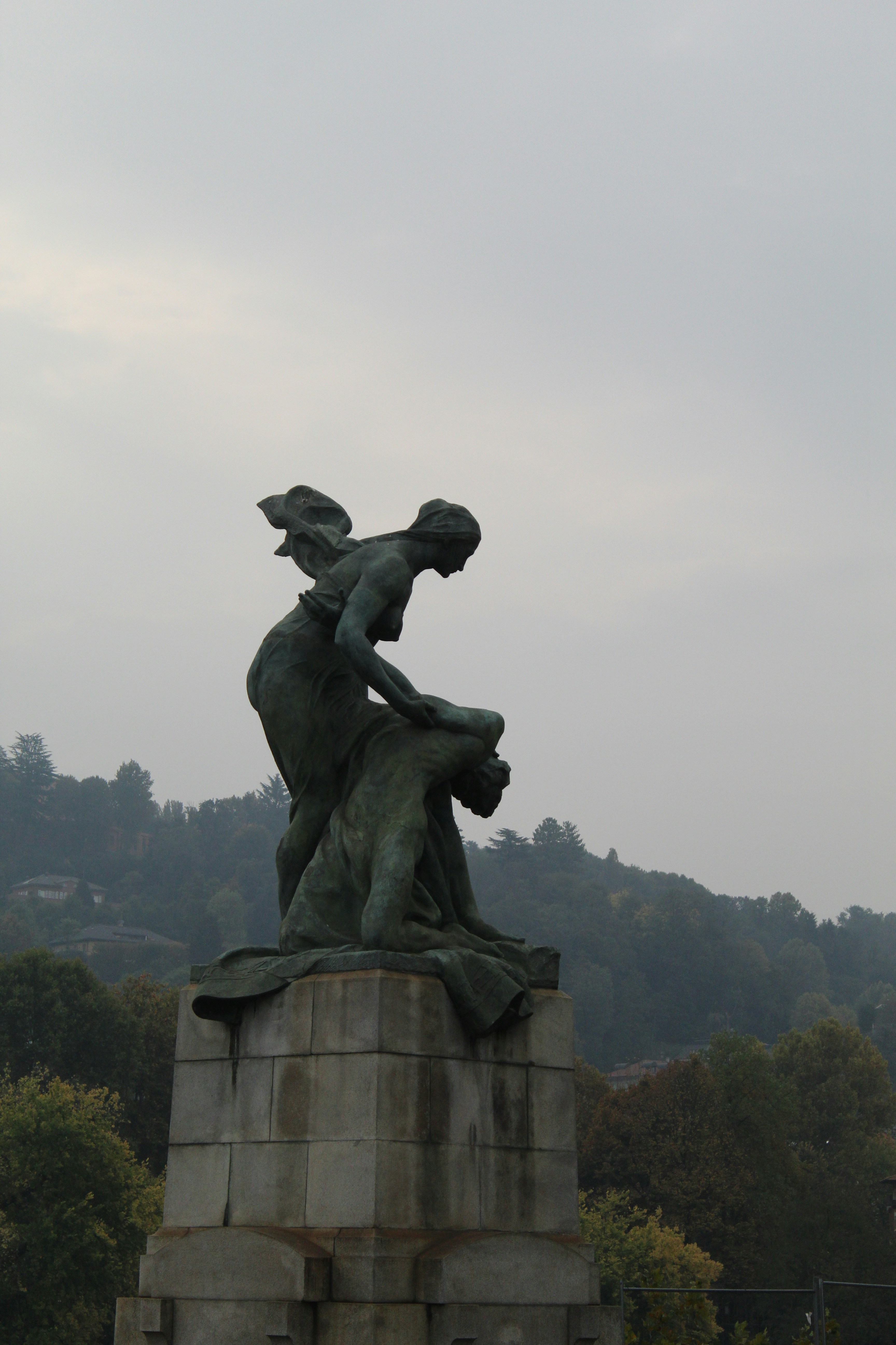 Bronze sculpture of two figures on a stone pedestal.