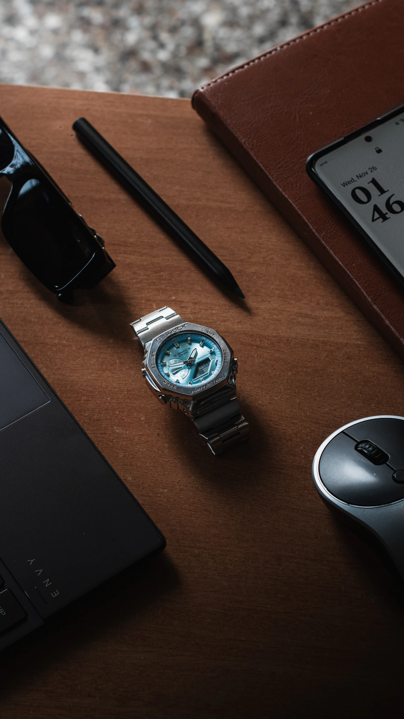 Armbanduhr, Notizbuch und Smartphone auf einem Schreibtisch als Symbol für zurückgewonnene Zeit