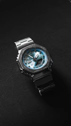 A silver and black watch with a blue face.