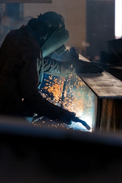 Welder working with sparks flying in workshop