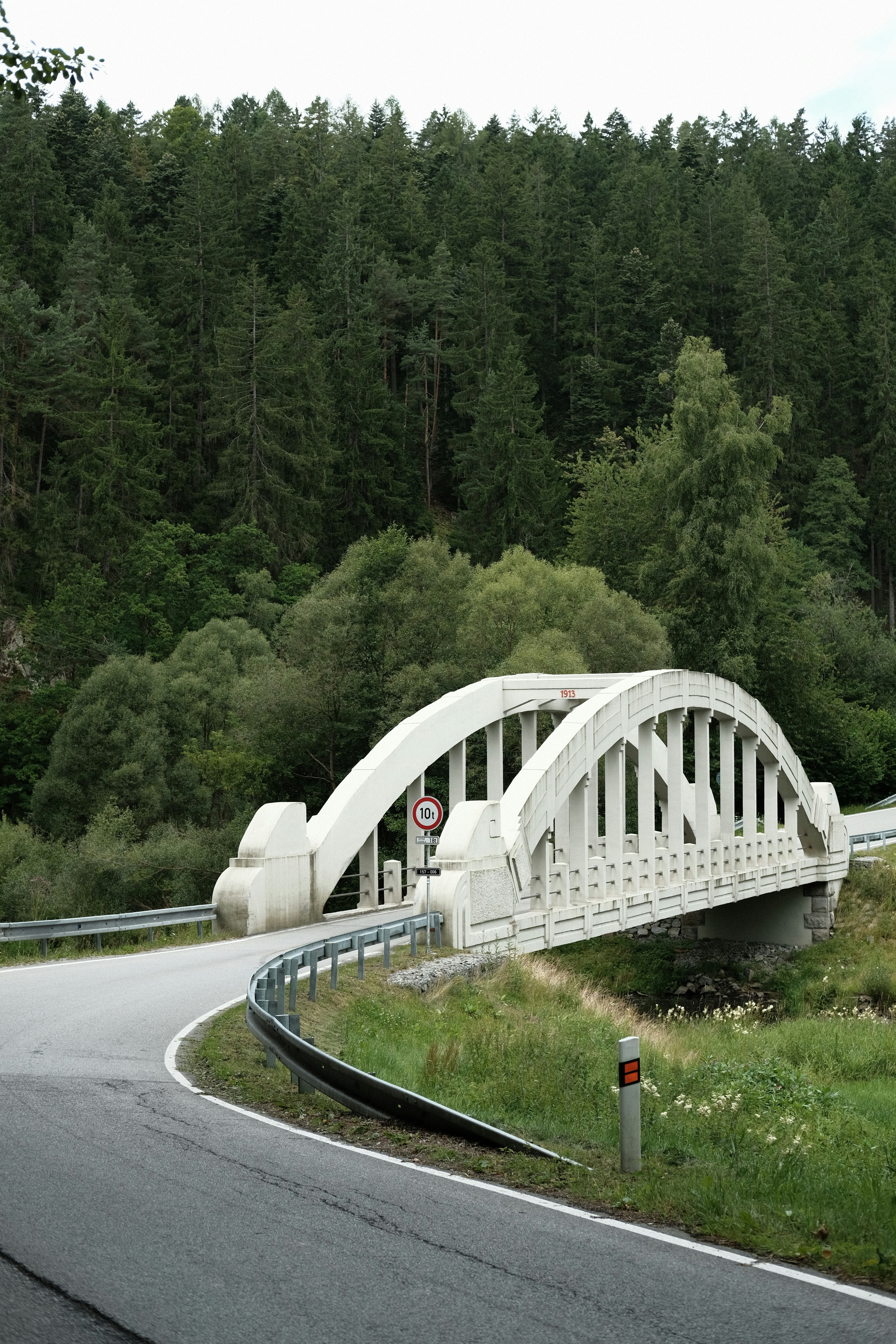 White arched bridge over a winding road