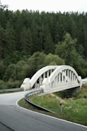White arched bridge over a winding road