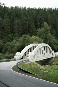 White arched bridge over a winding road