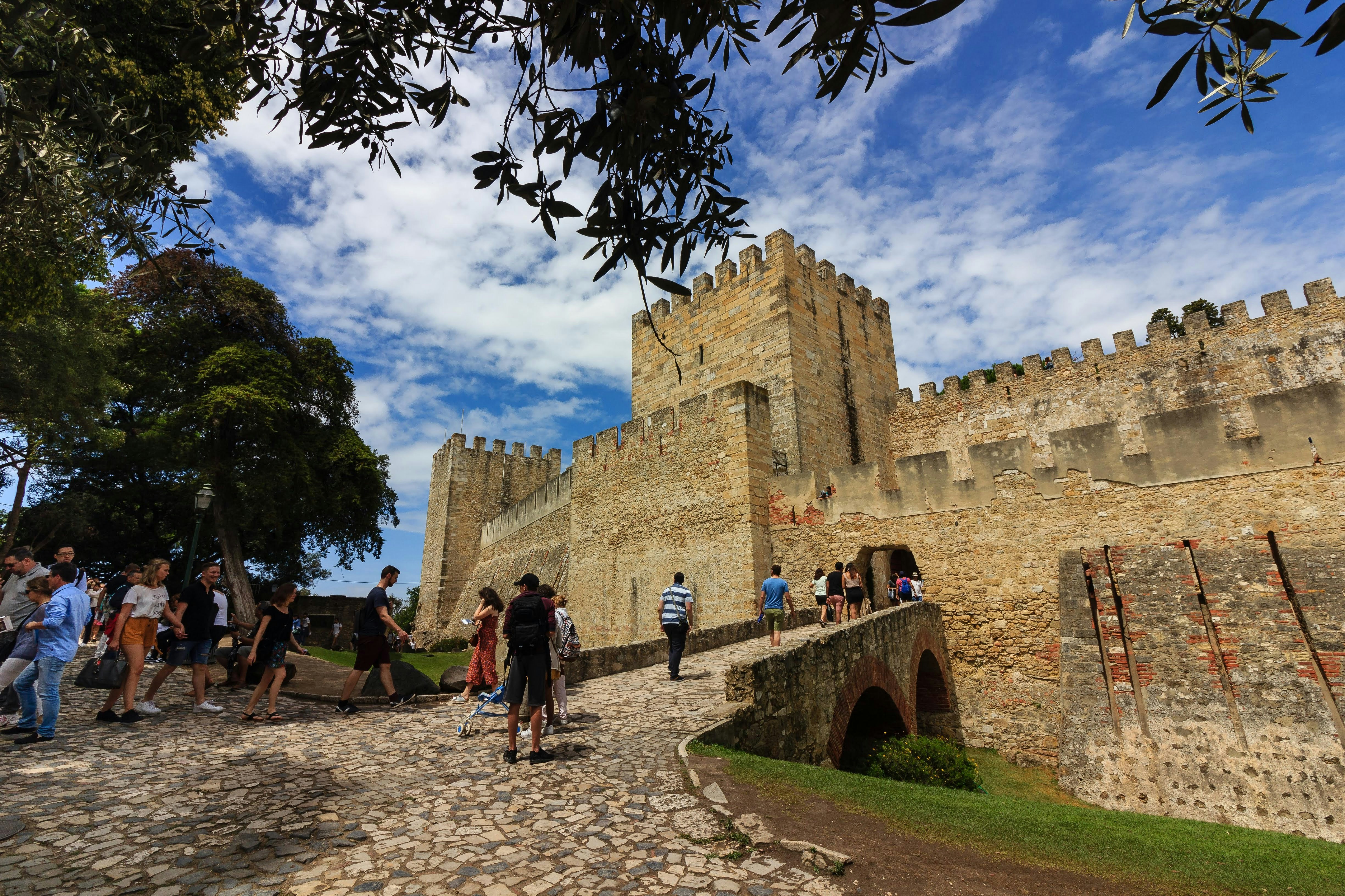 Stone castle walls with people walking on path