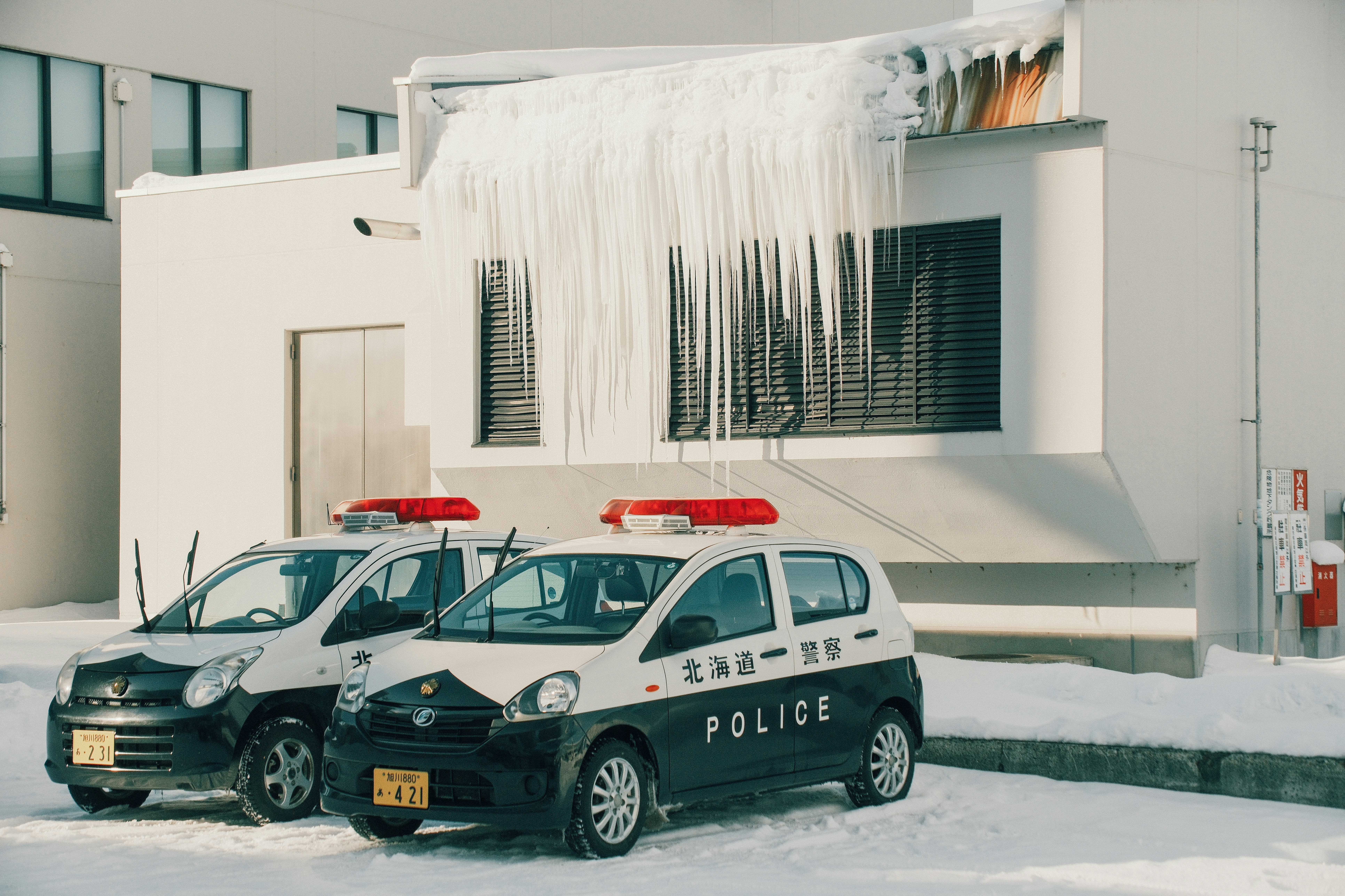 Police car in front of Japanese building with snow on roof