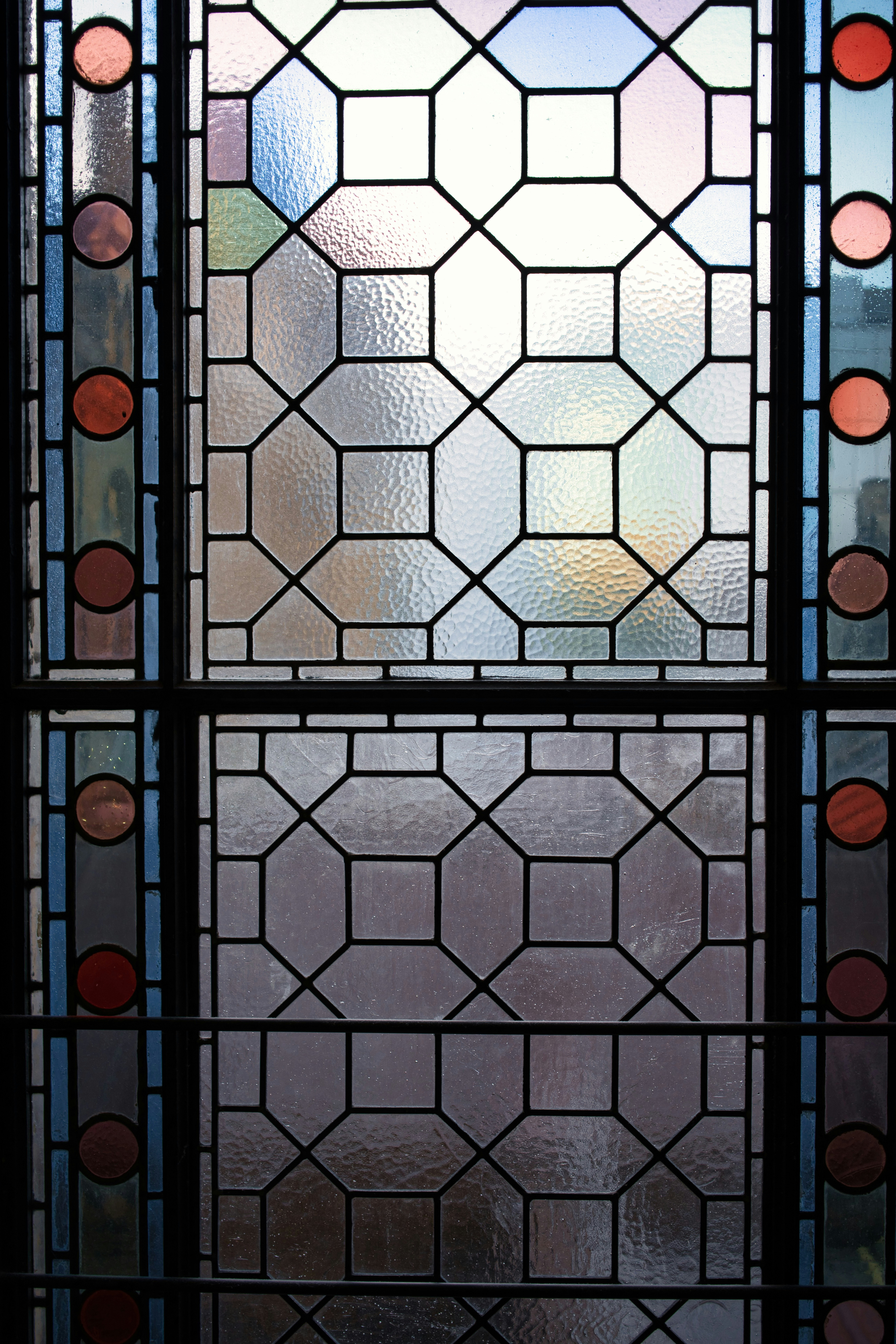 Geometric stained glass window with colorful reflections