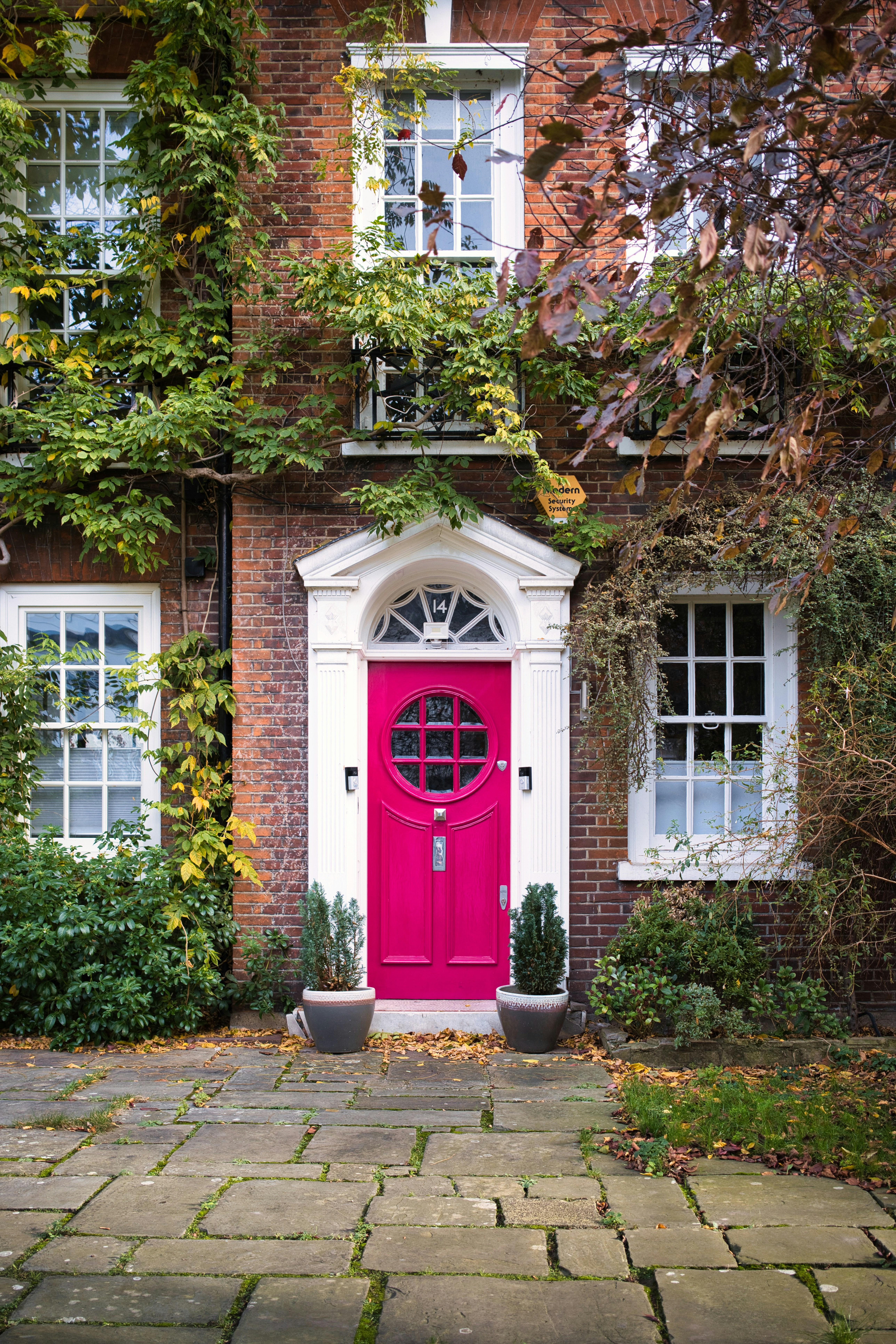 A bright pink door on a brick house