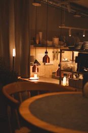 Warmly lit kitchen with pendant lights and wooden chair.