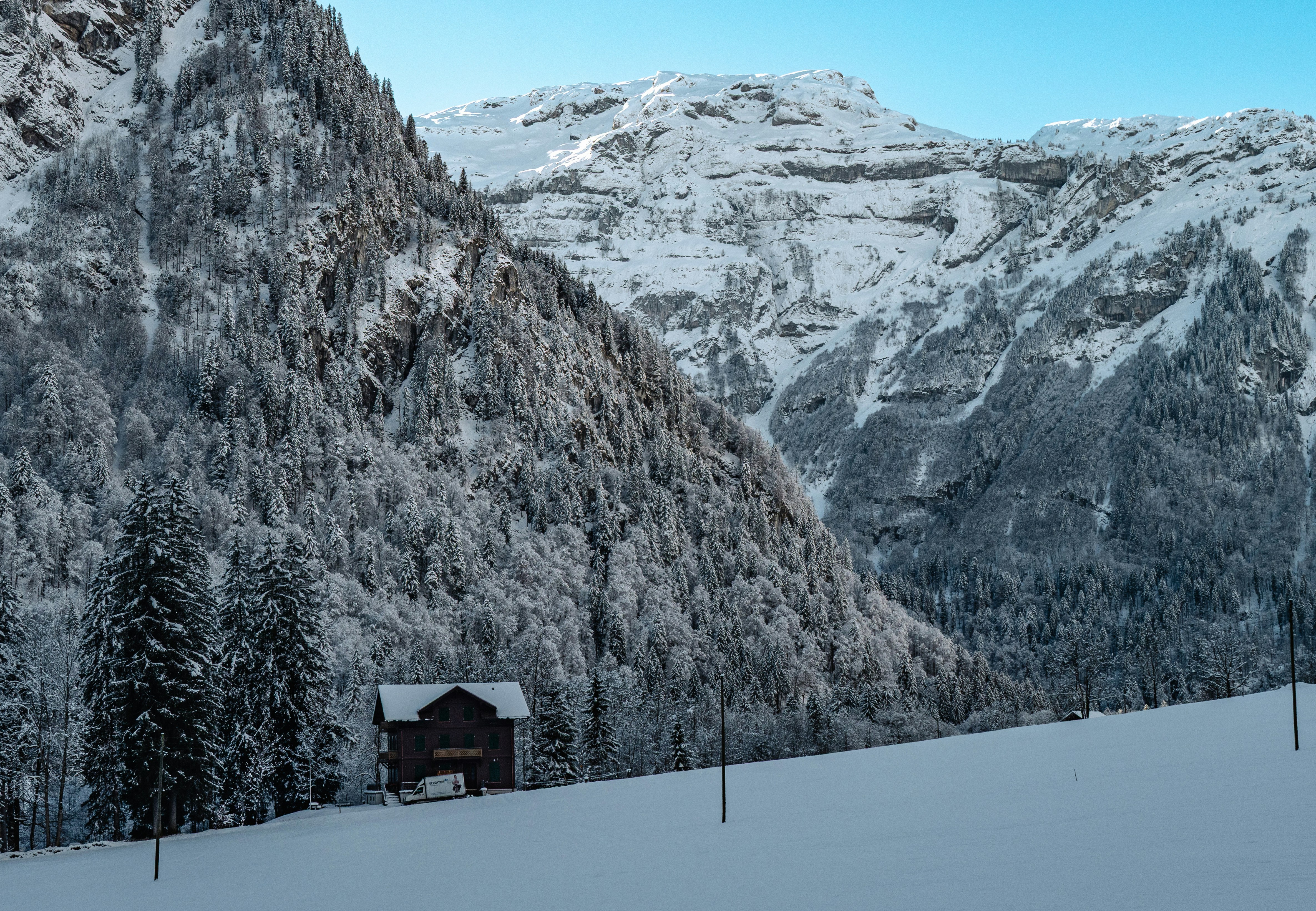 Snow covered mountains and a small cabin.