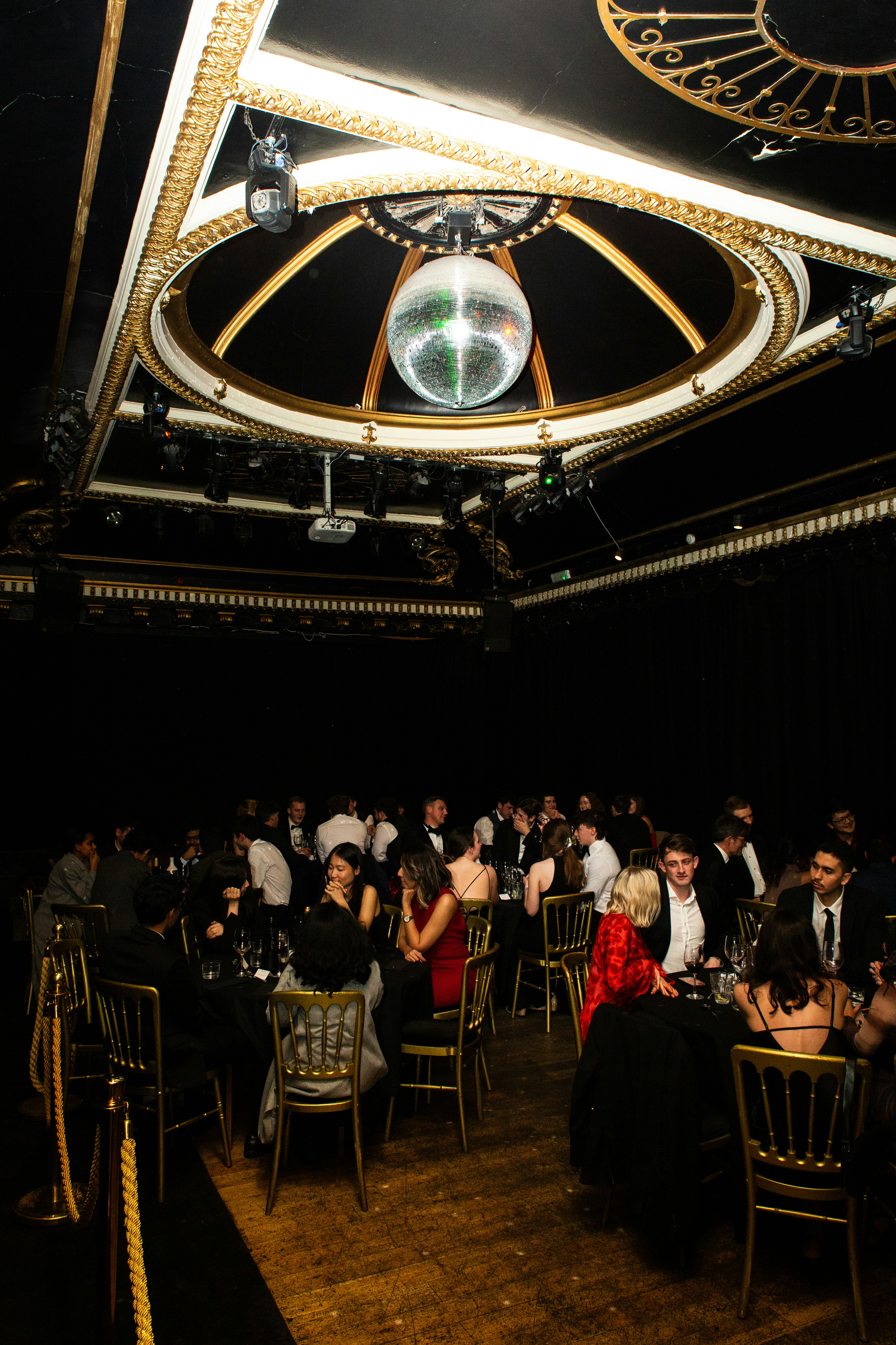 People dining at tables under a disco ball.