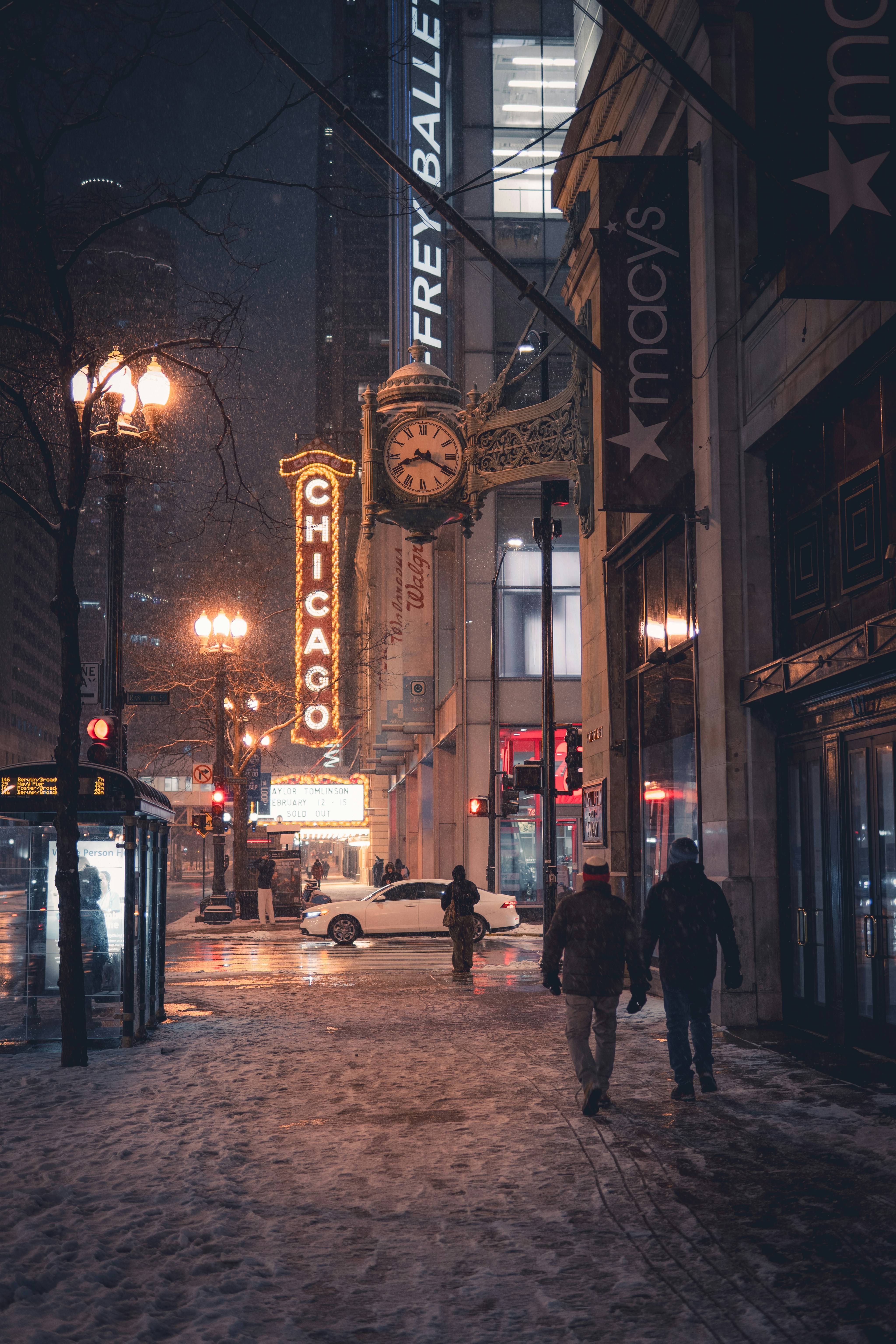Menschen laufen nachts eine verschneite Straße in Chicago entlang