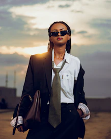 Woman in suit and sunglasses at sunset