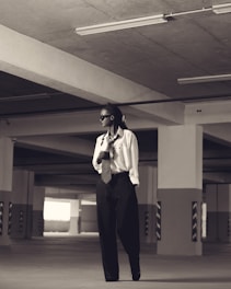 Woman in formal attire stands in a parking garage.