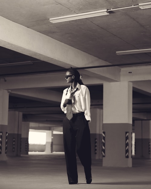 Woman in formal attire stands in a parking garage.