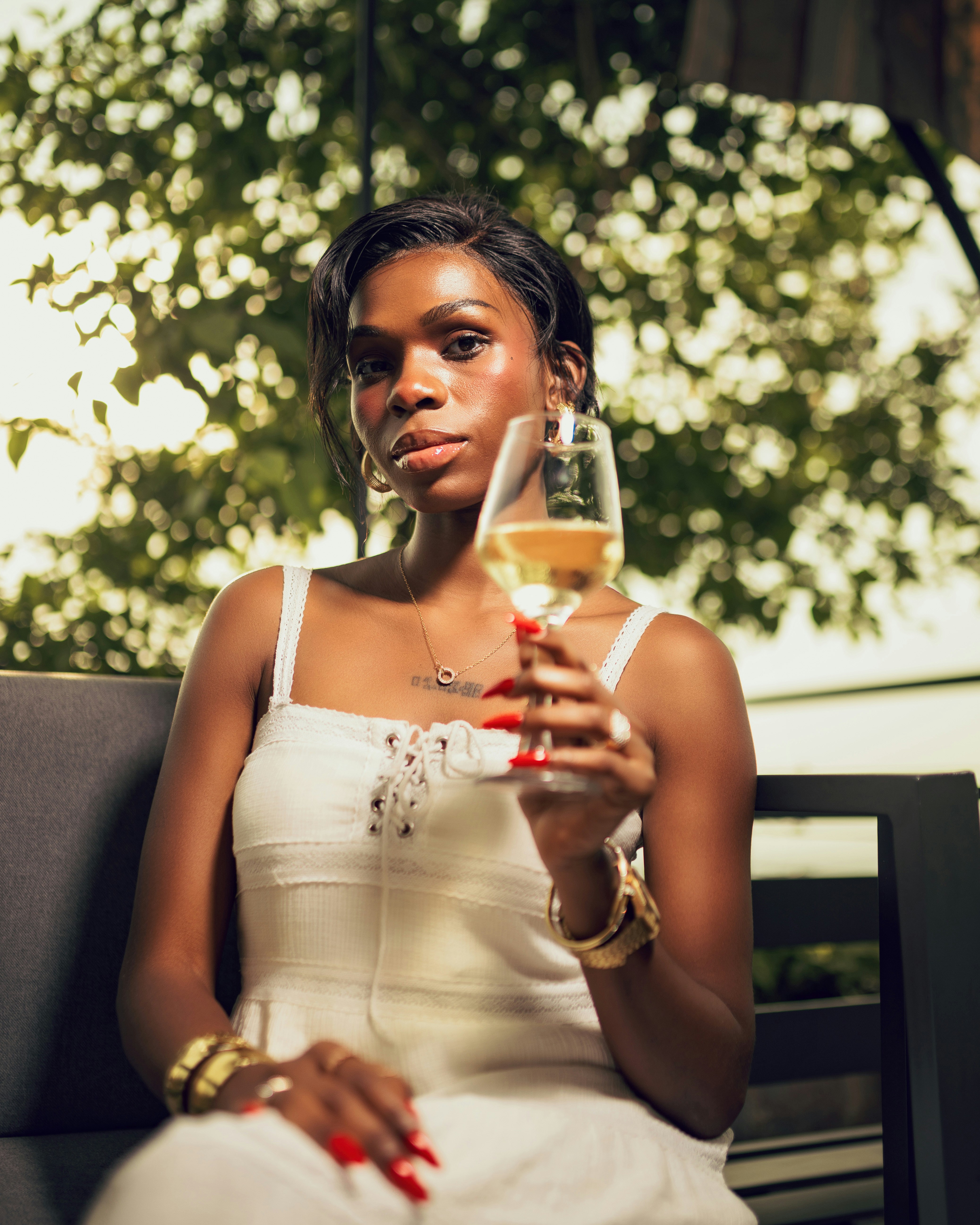 Woman in white dress holding champagne glass outdoors