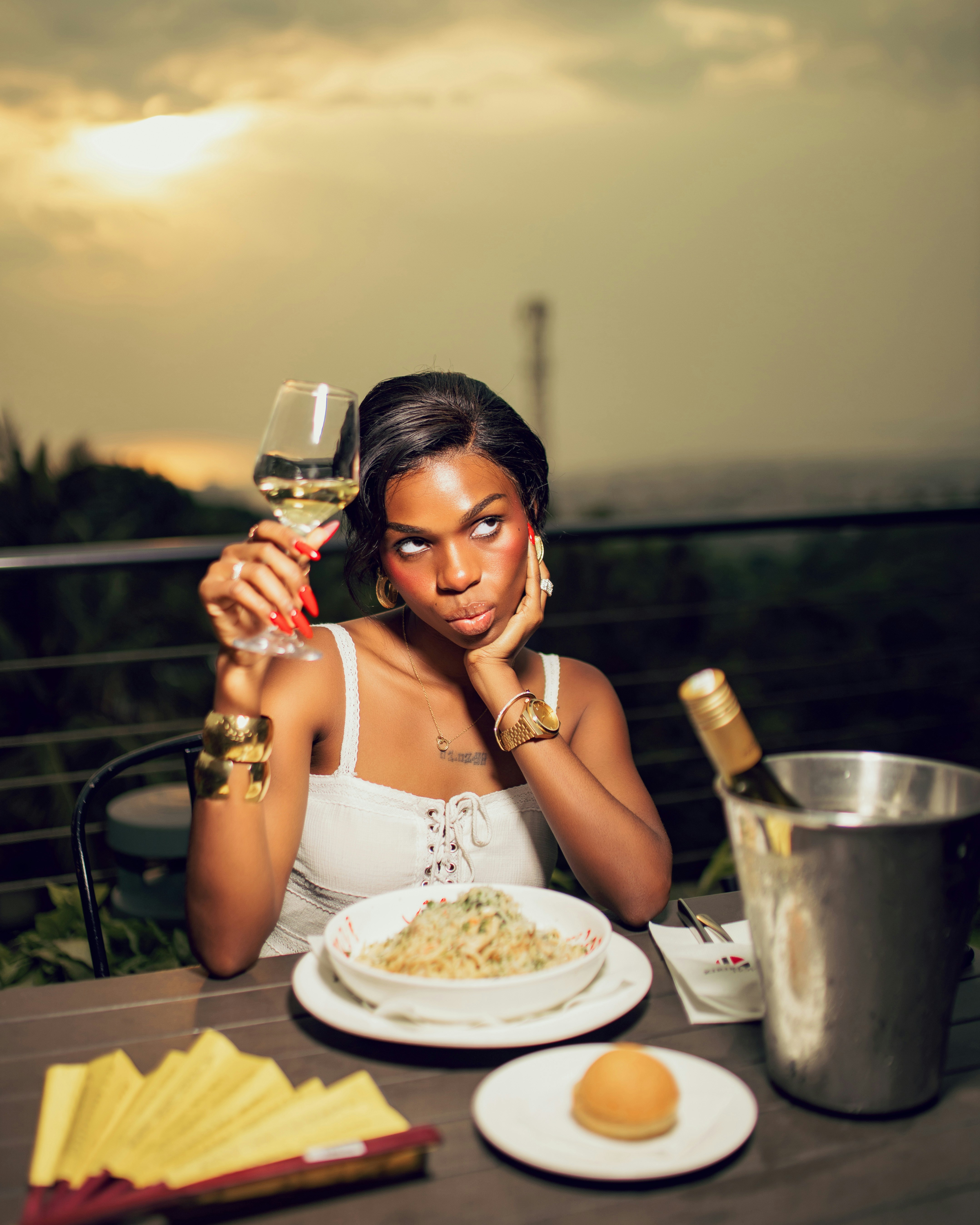 Woman holding wine glass at outdoor table with food