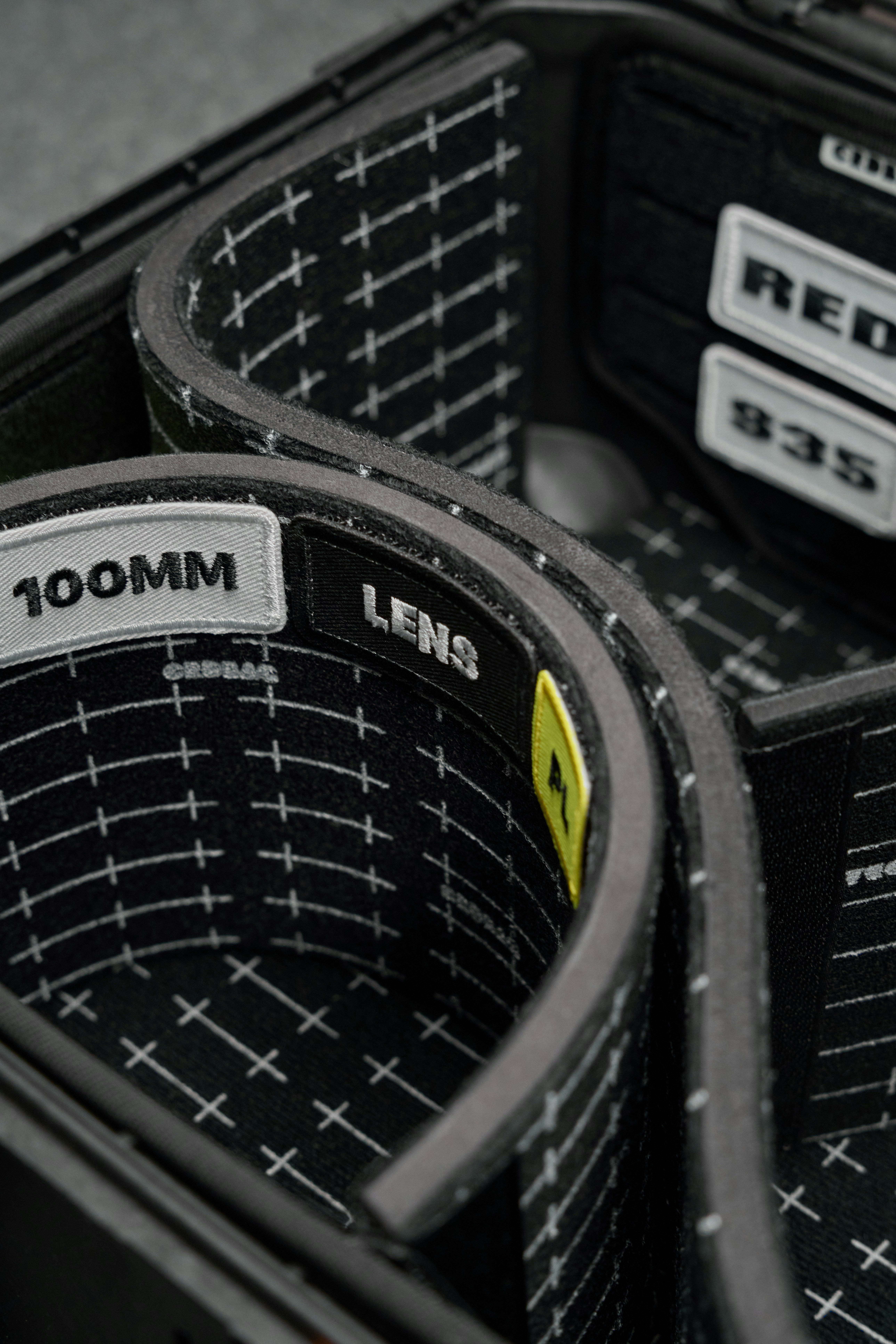 Camera lens case with padded compartments and labels.