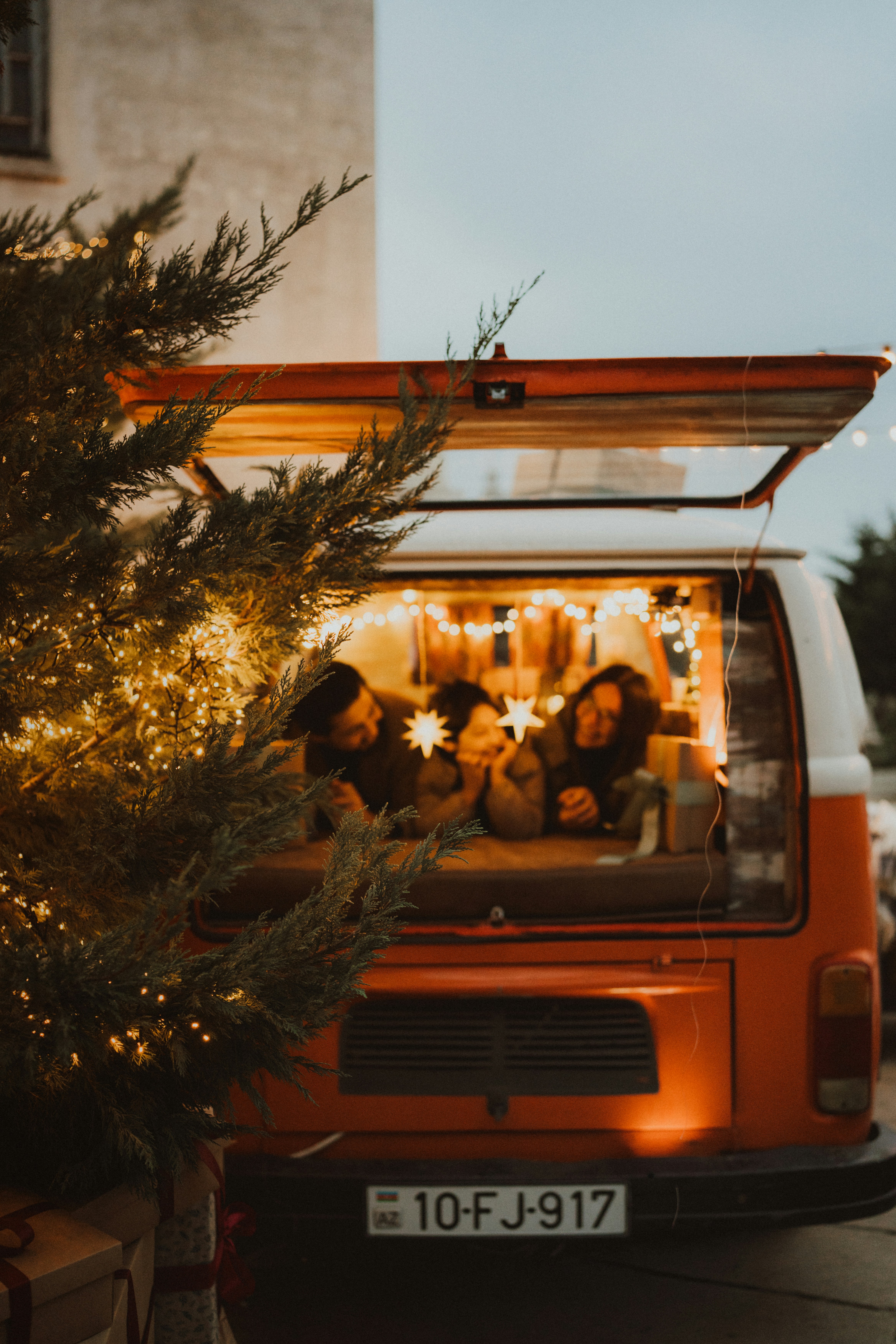 People relaxing inside a vintage camper van at night.