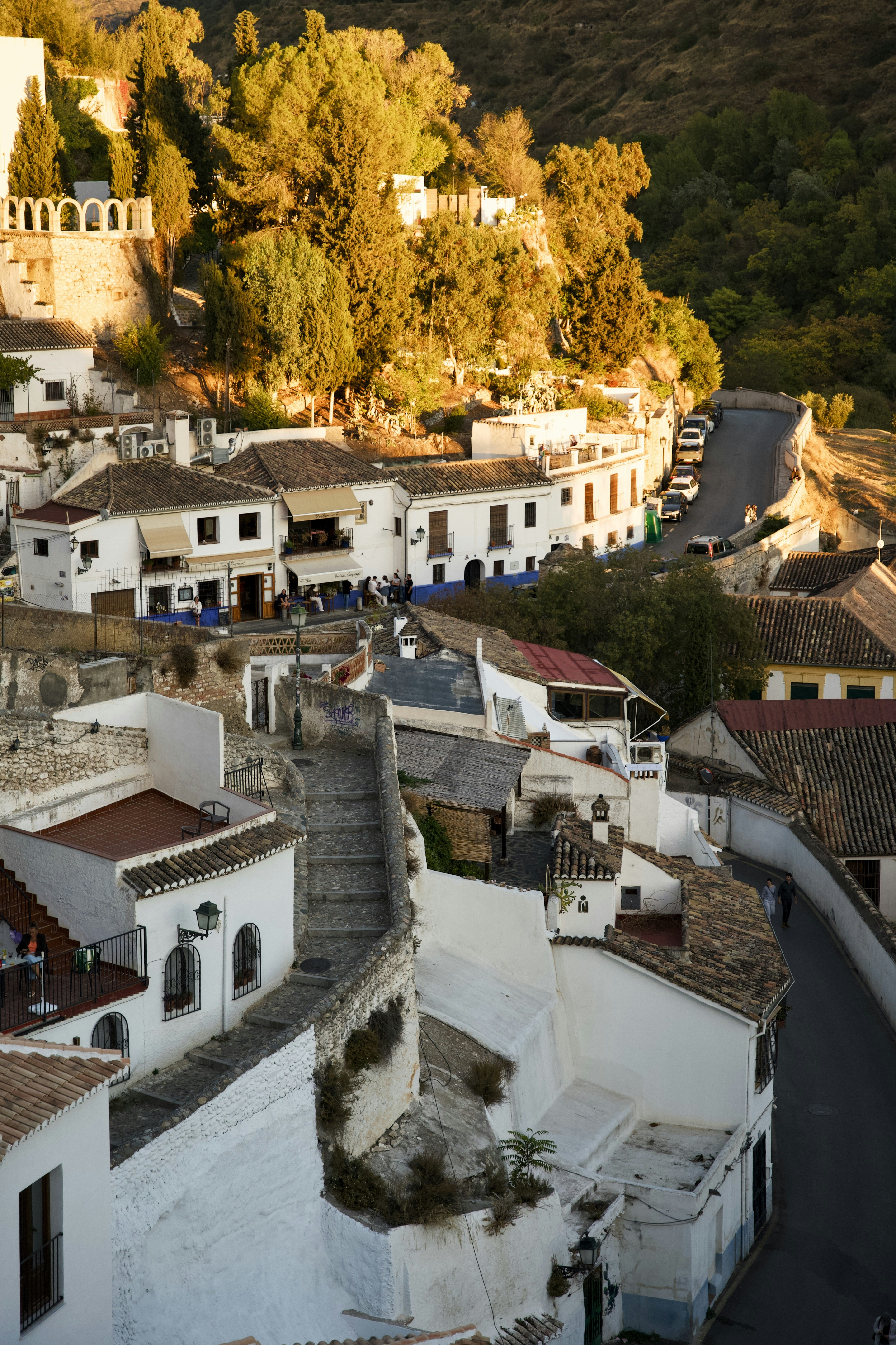 Prédios brancos em uma encosta ao pôr do sol.