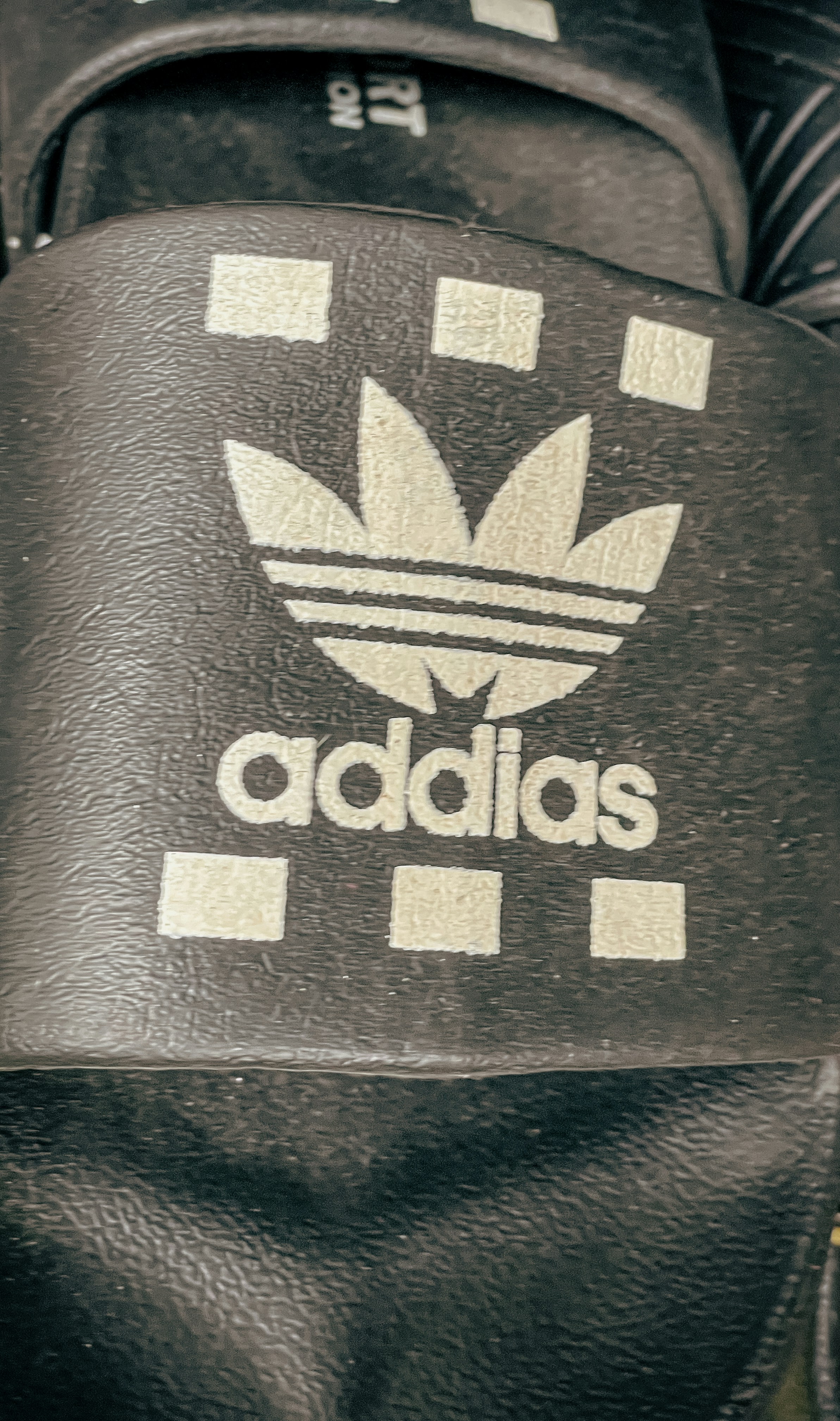Black slides with a white 'addias' logo