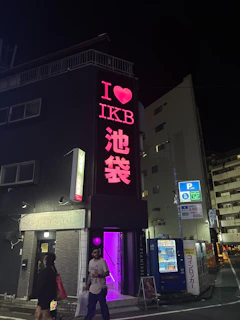 Building with "i love ikb" neon sign at night.