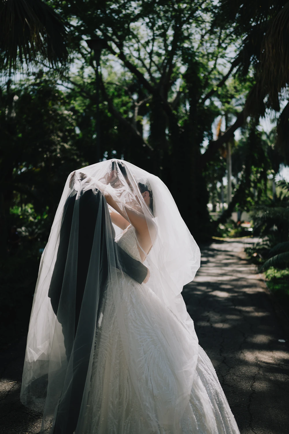 Couple embracing in a garden, bride holding a bouquet