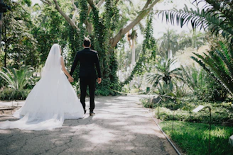 Bride and groom walking in a lush garden