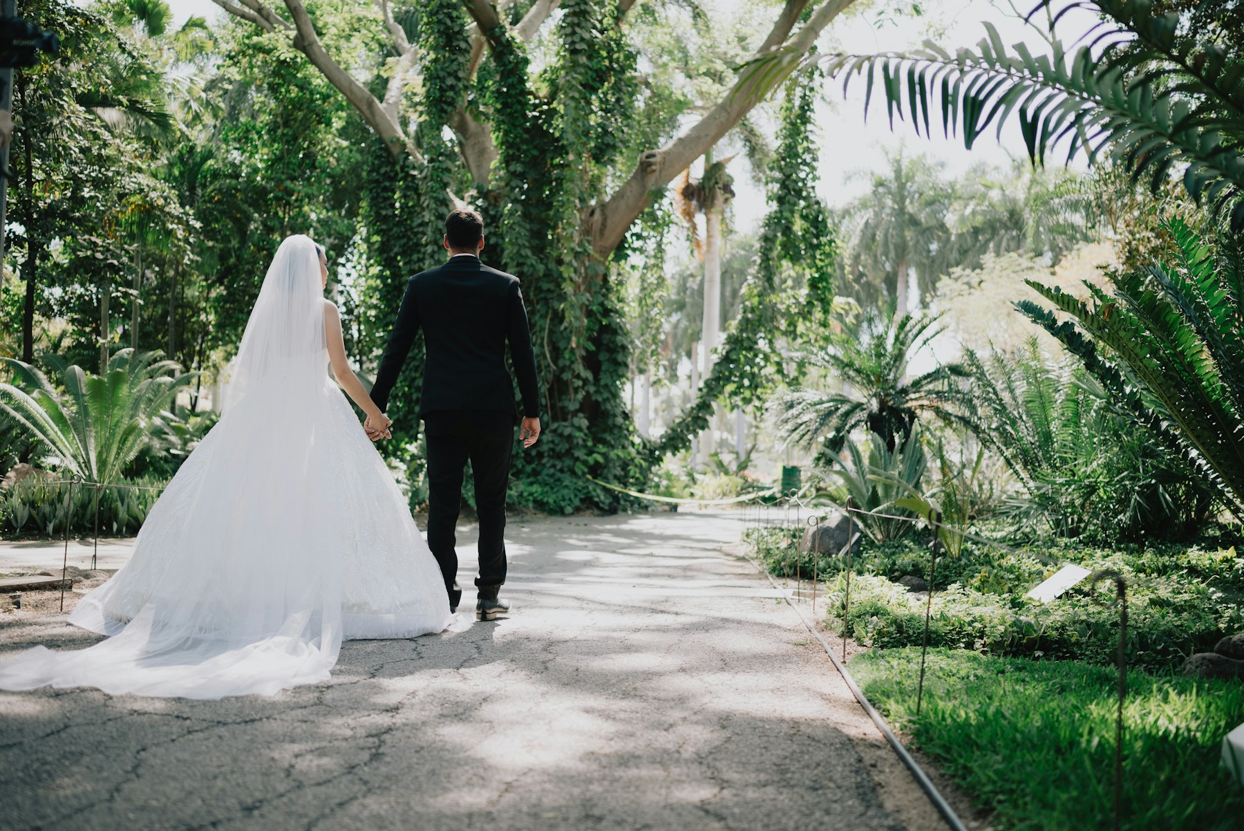 Couple walking through a wedding venue garden terrace during a tour
