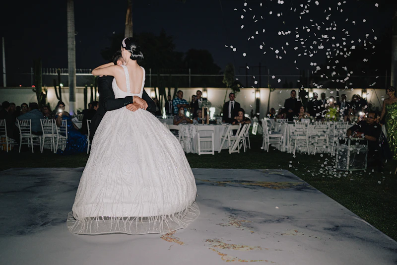 Bride and groom dancing at night wedding reception.