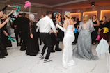 People dancing at a formal event with colorful fans