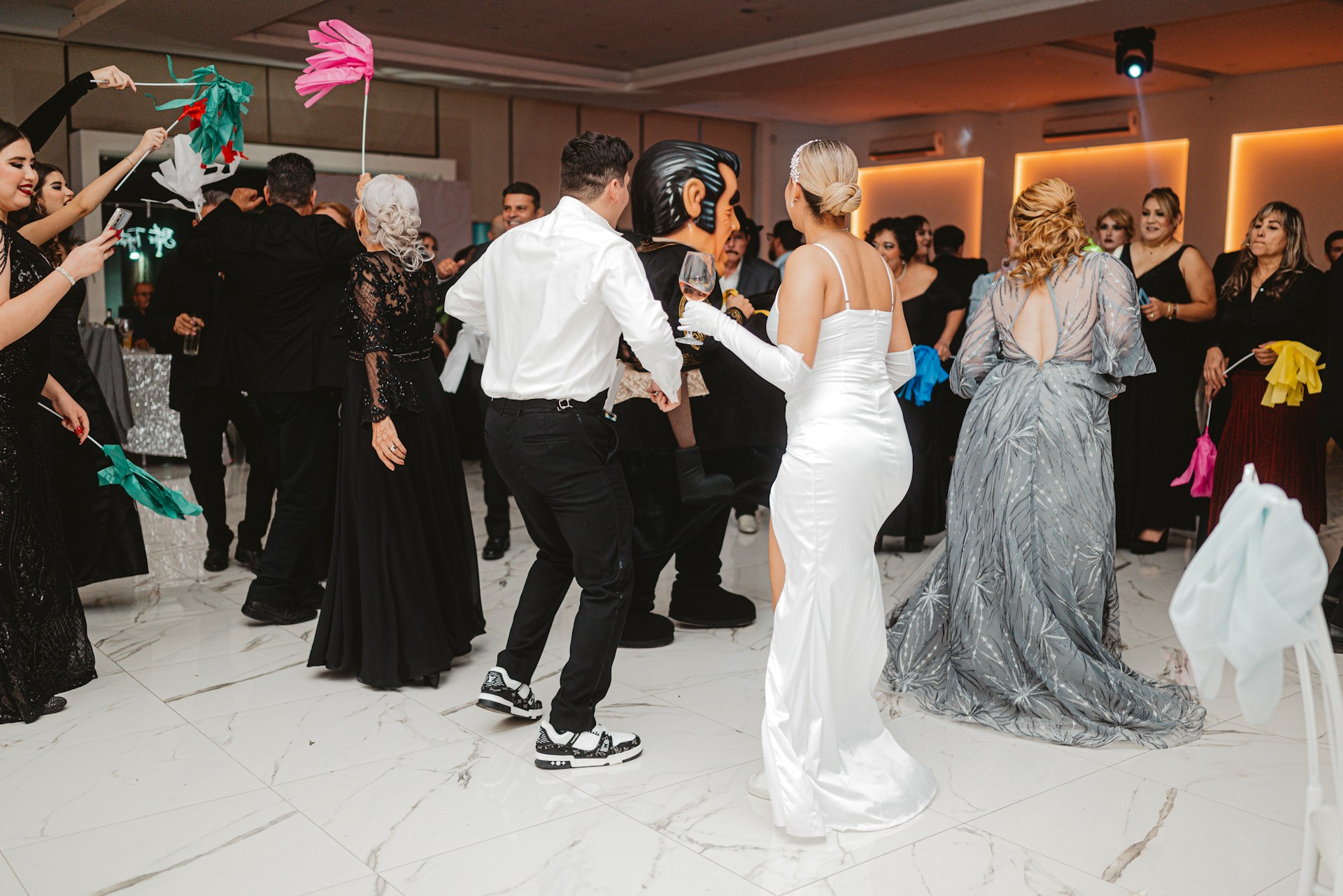 People dancing at a formal event with colorful fans