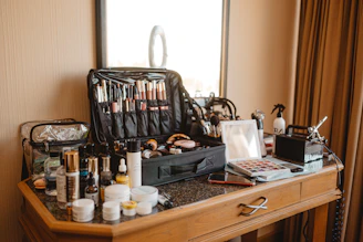 Makeup artist's kit spread across a wooden vanity table.