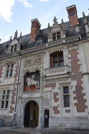 Ornate facade of a historic building with equestrian statue.