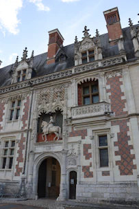 Ornate facade of a historic building with equestrian statue.