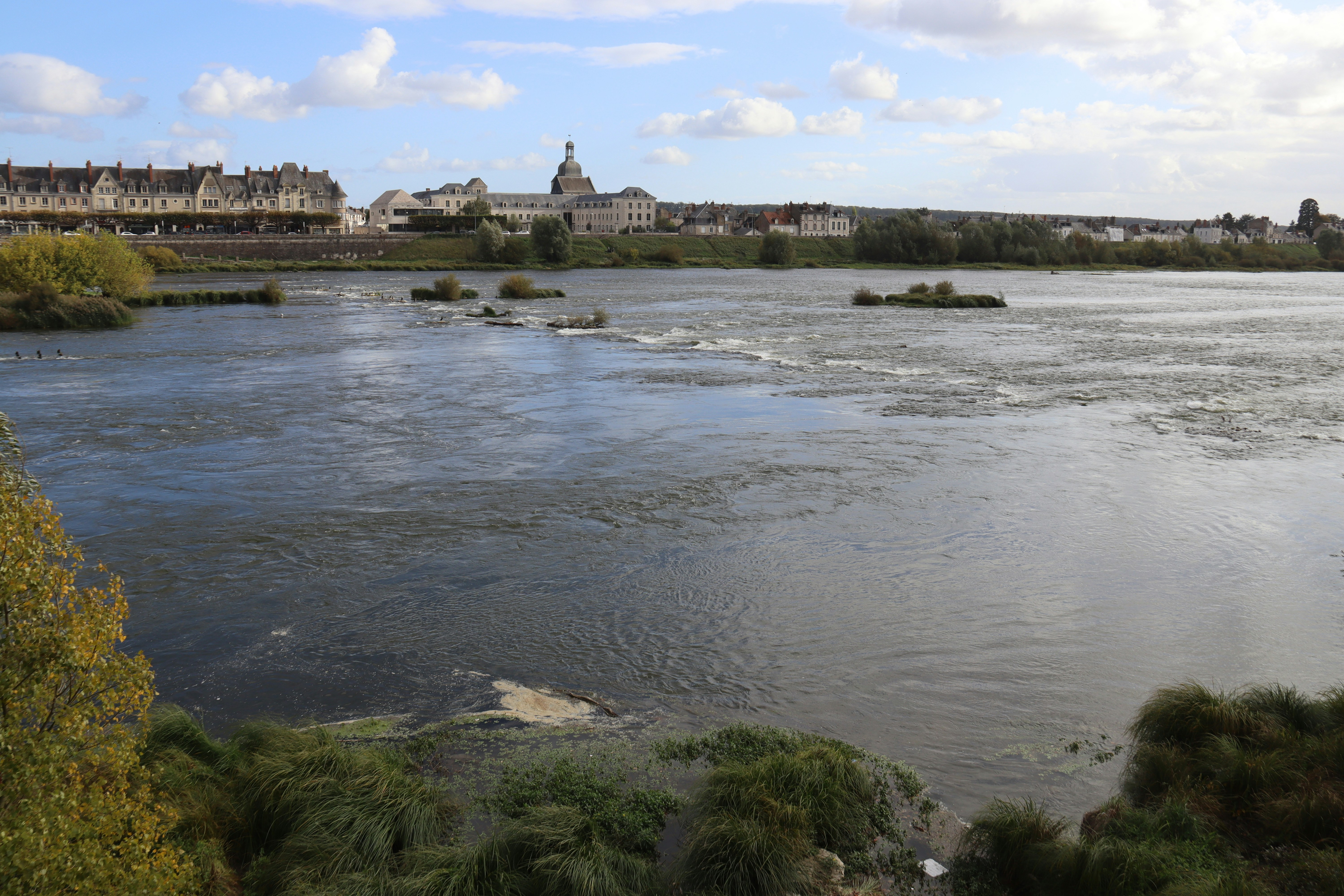 Wide river with buildings and trees on shore