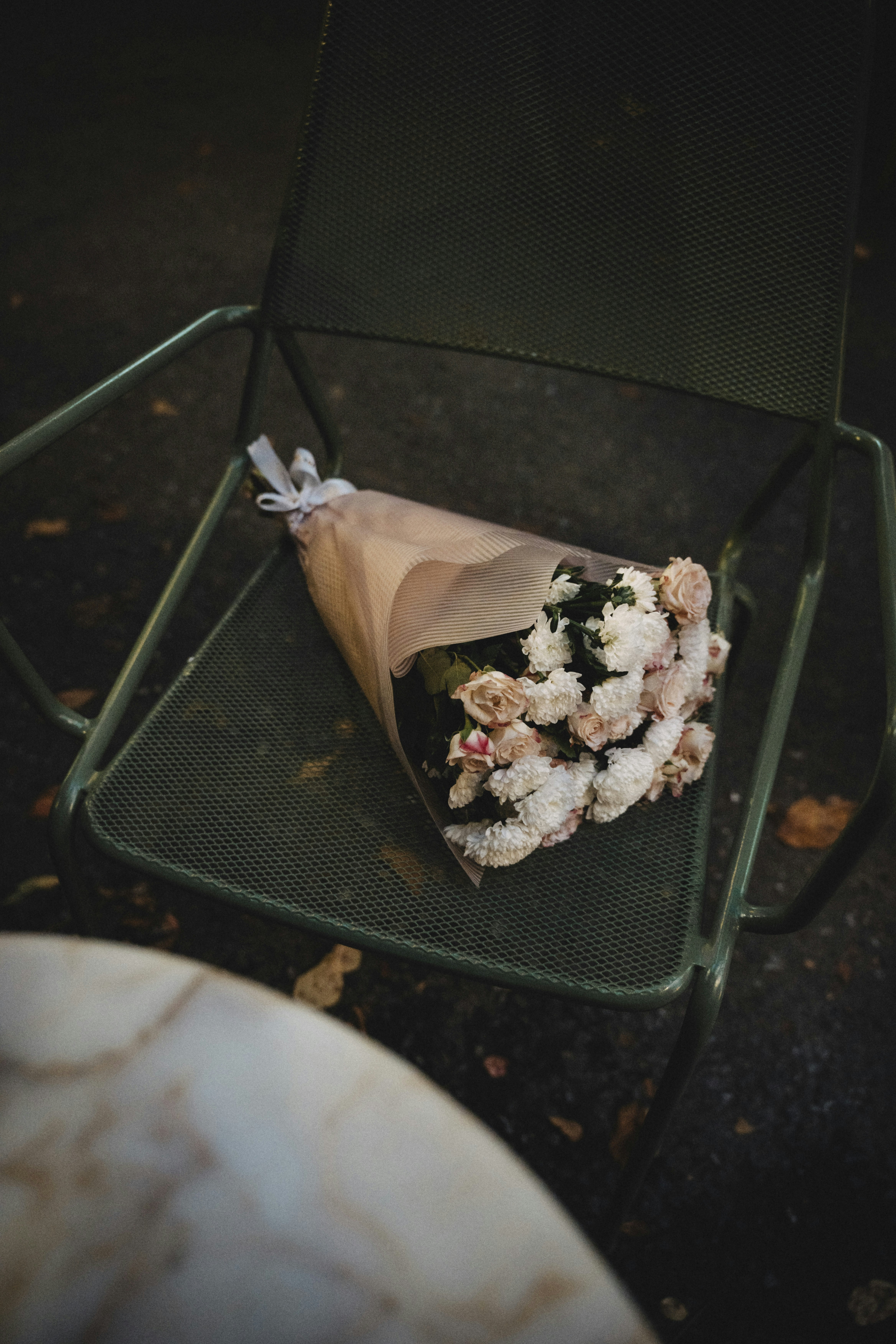 Bouquet of flowers resting on a green chair.