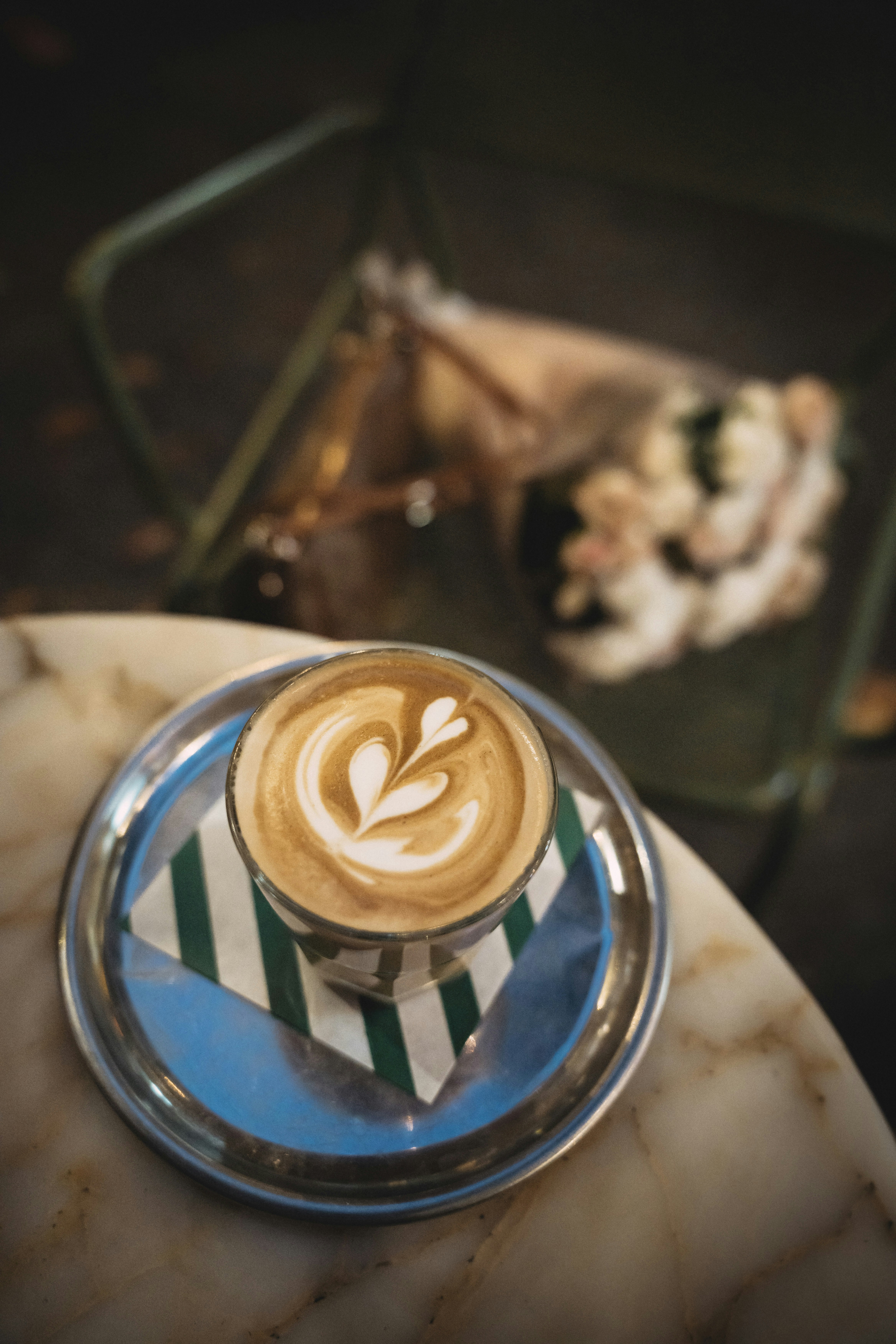Arte con latte en un vaso sobre un platillo