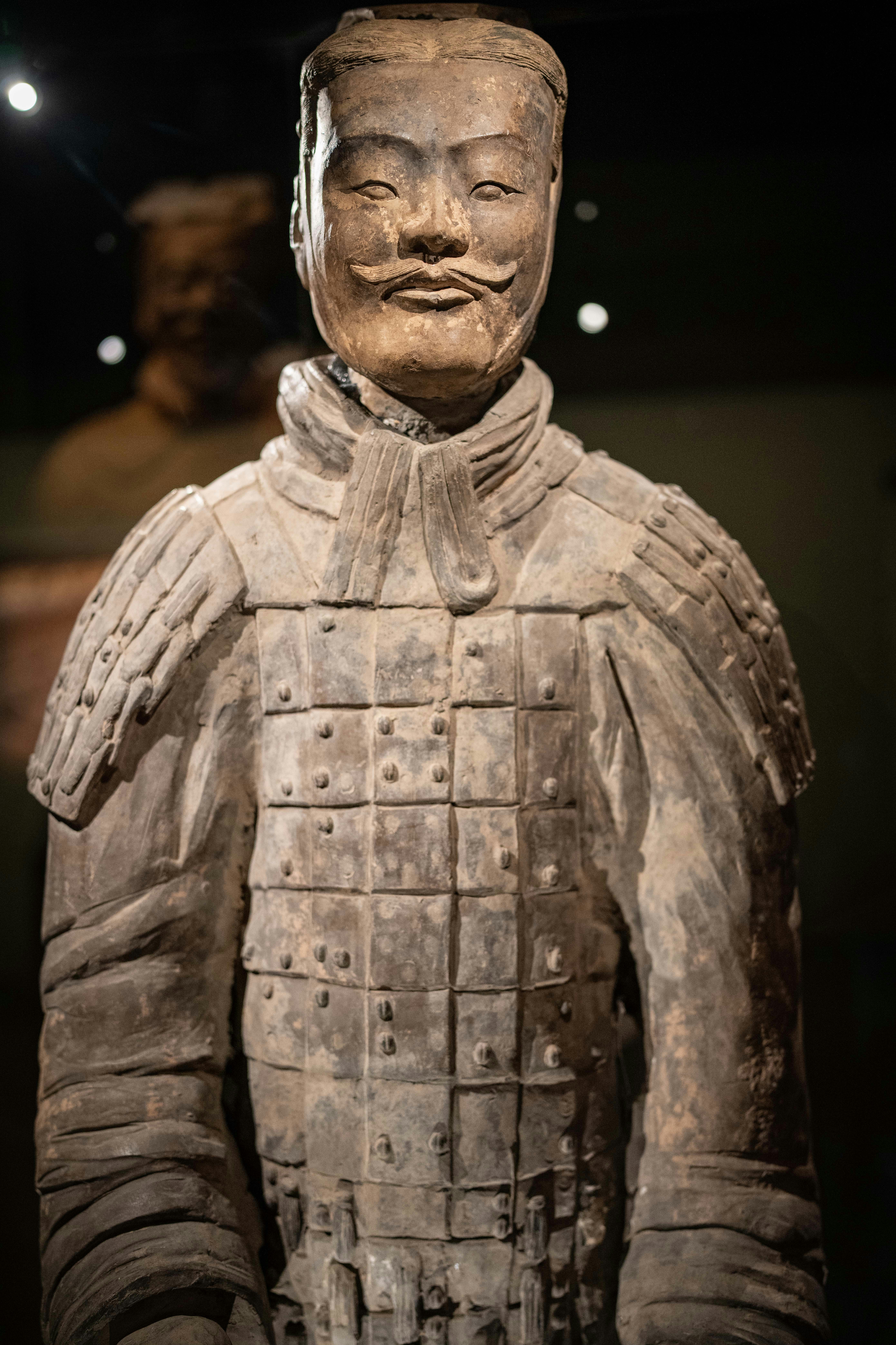 Terracotta warrior statue with armor and mustache.