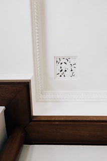 White ceiling with decorative molding and vent.