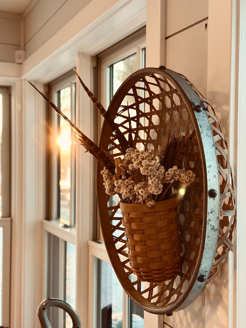 Cesto in vimini con fiori secchi su parete in legno