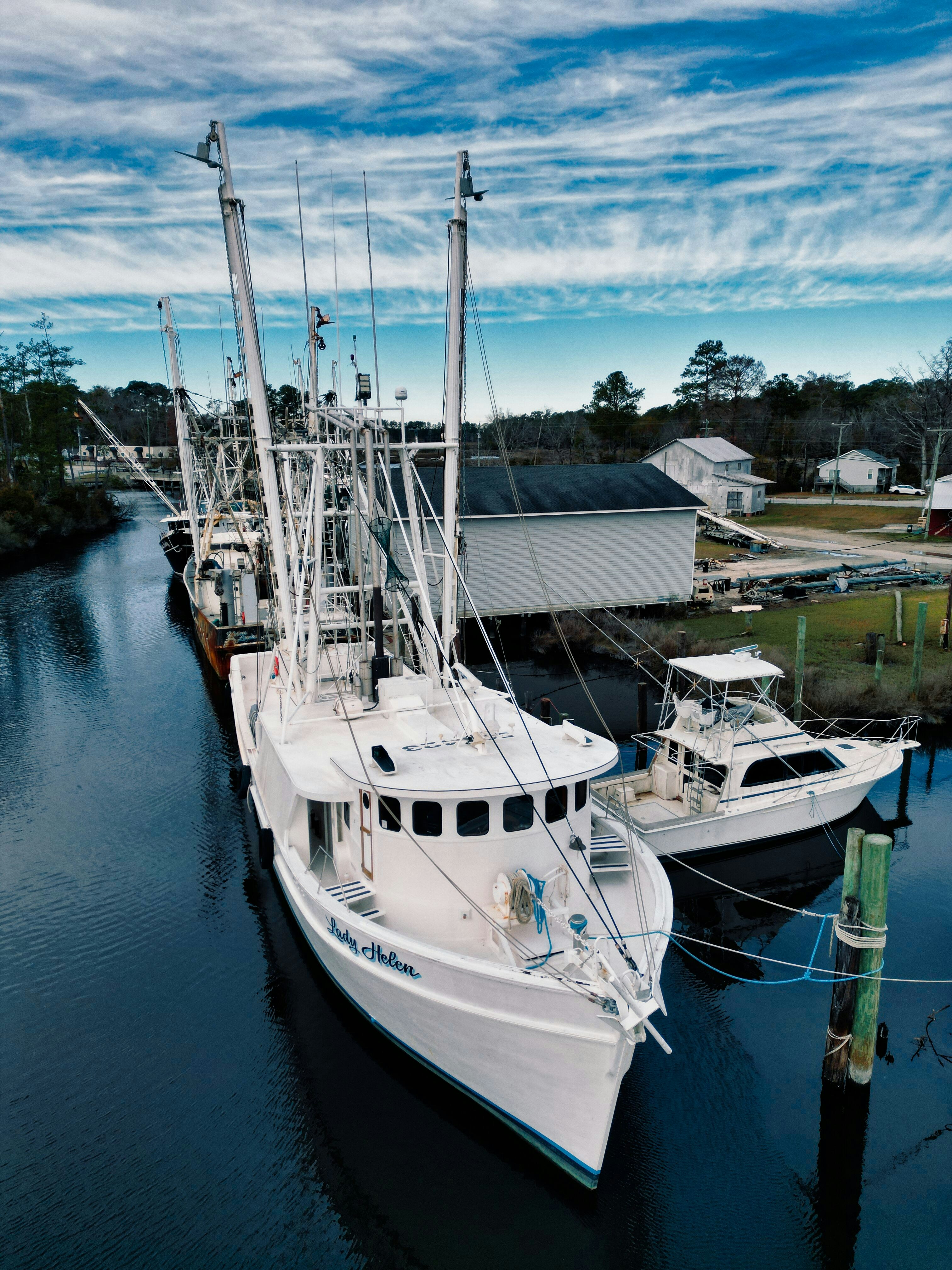 Barcos de pesca atracados en un tranquilo canal azul.