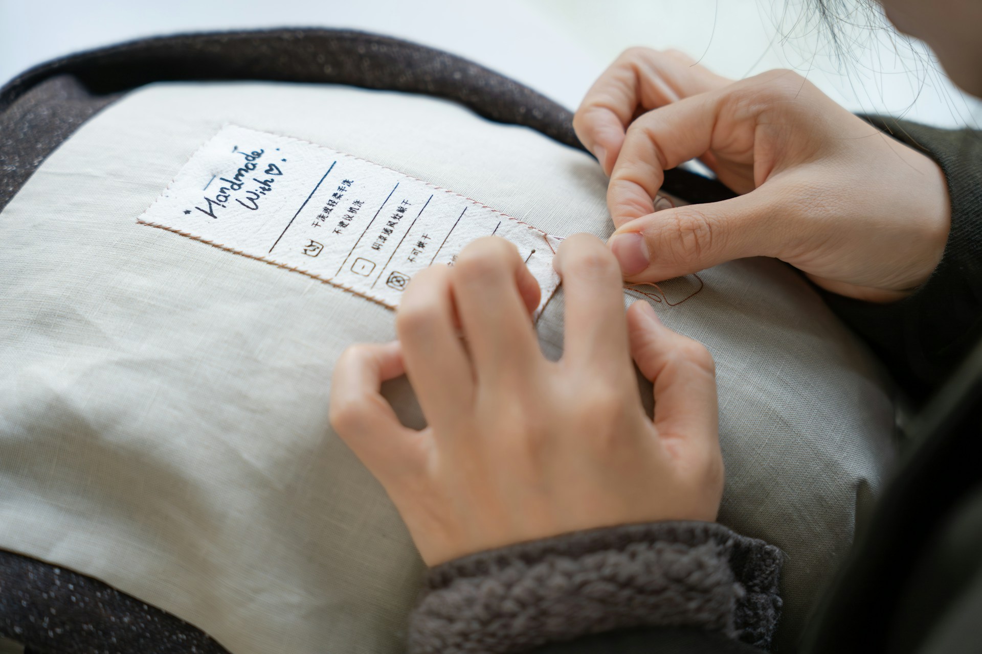 Hands attaching a label to a garment