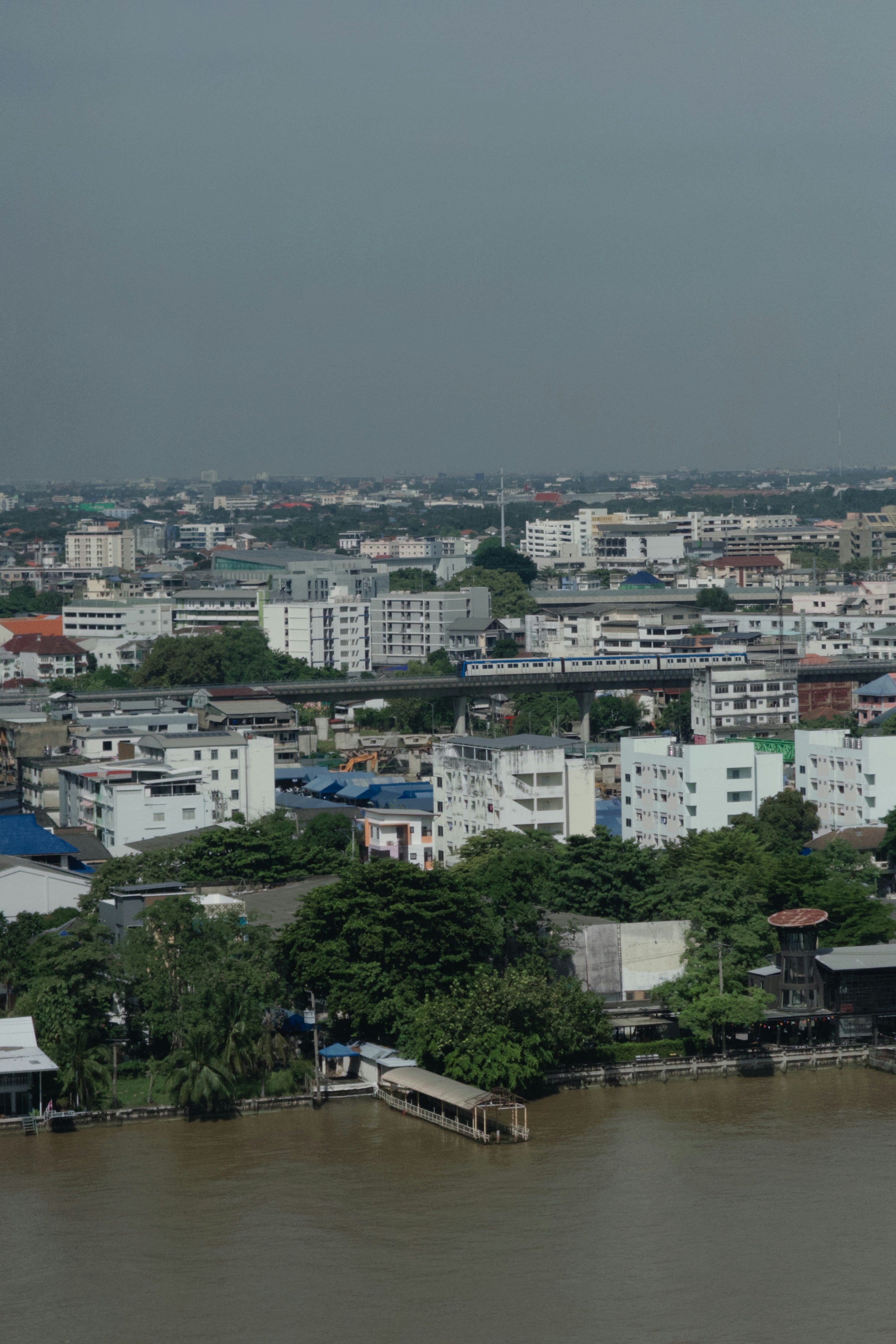 Paisaje urbano con río y edificios bajo cielo nublado