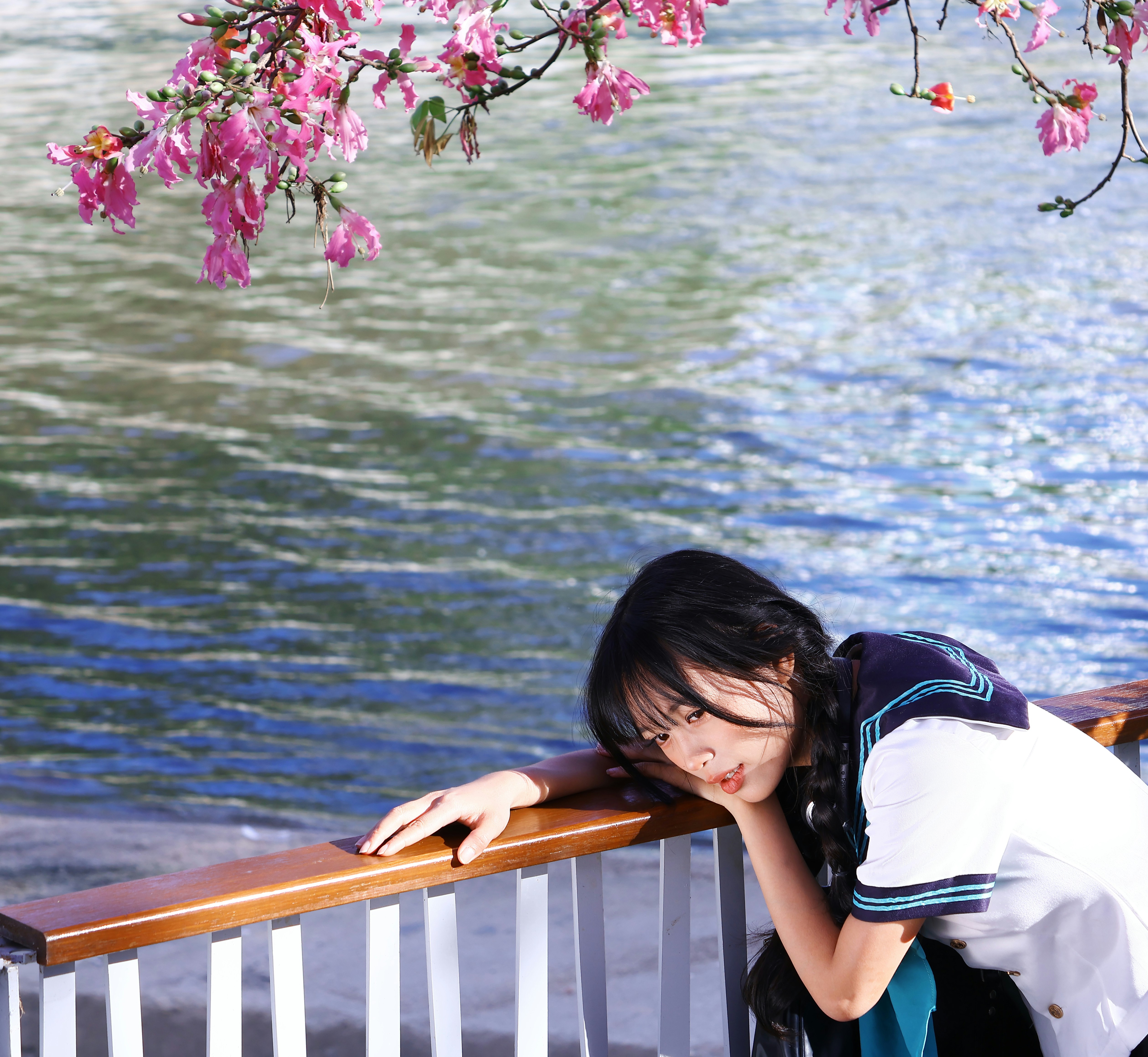 Young woman in sailor uniform by the water