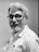 Man with glasses and beard in a white shirt.
