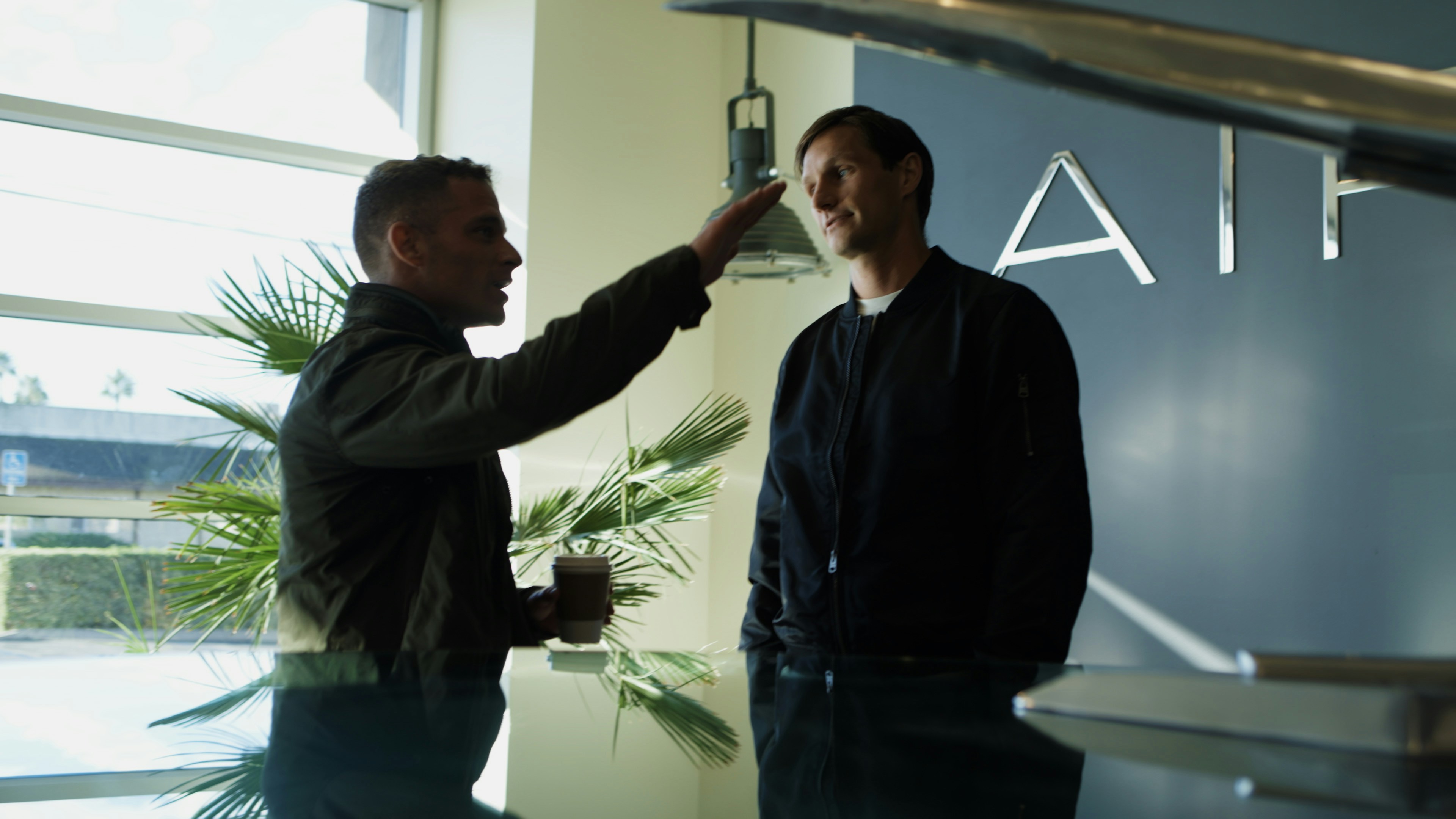 Two men talking near an airplane model