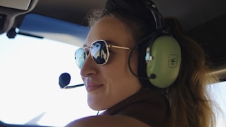 Woman wearing headset and sunglasses in cockpit